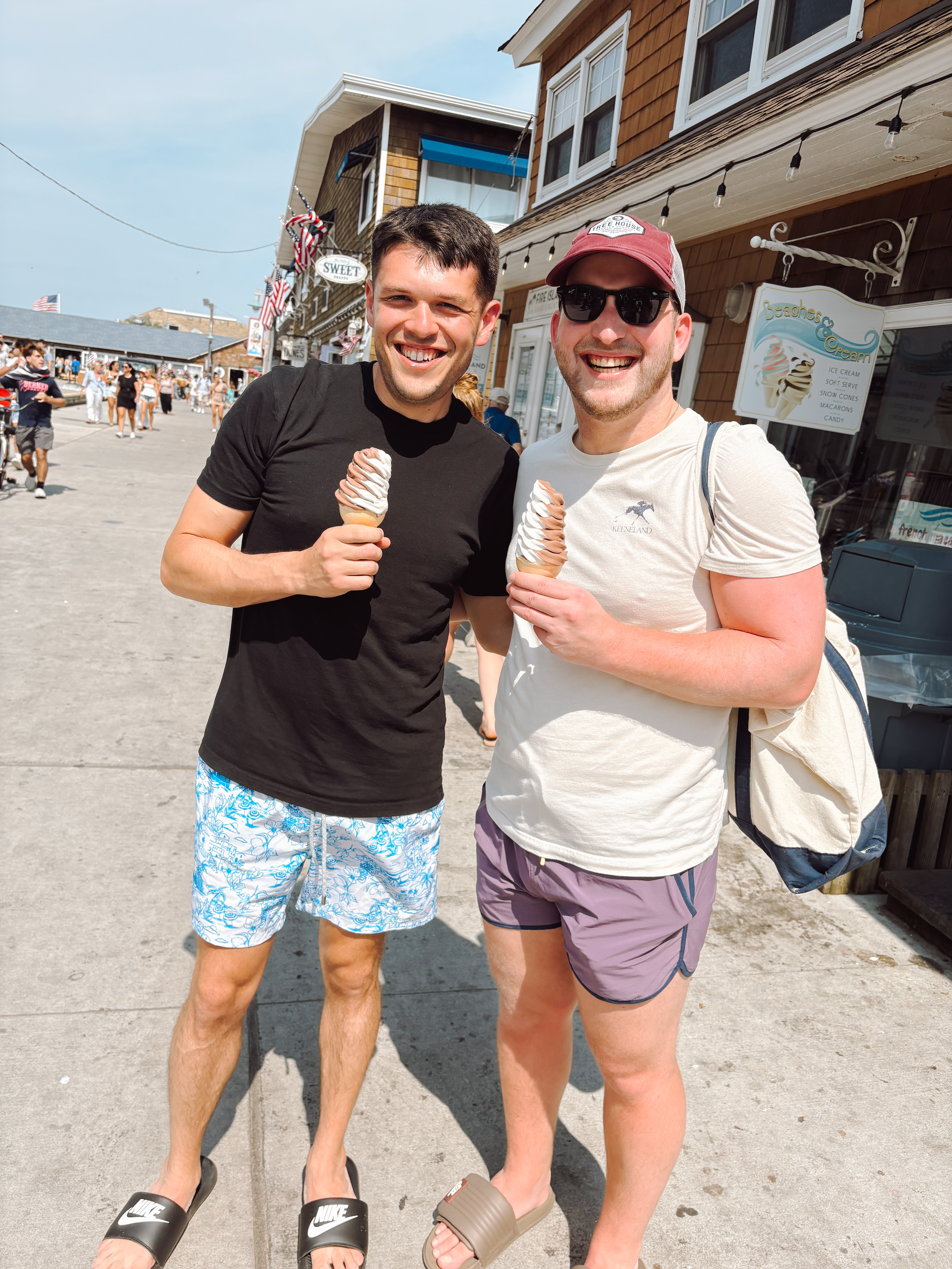 Ian and Zach holding ice cream cones at a beach boardwalk